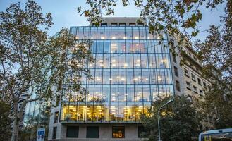 edificio con bicchiere facciata nel il moderno città. ufficio edificio con verde ambiente. foto