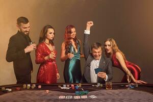 gruppo di un' giovane ricco amici siamo giocando poker a un' casinò. foto