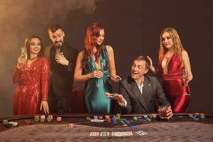 gruppo di un' giovane ricco amici siamo giocando poker a un' casinò. foto