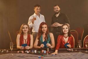 gruppo di un' giovane ricco amici siamo giocando poker a un' casinò. foto