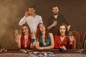 gruppo di un' giovane ricco amici siamo giocando poker a un' casinò. foto