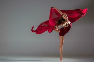 bellissimo donna ballerino indossare marrone costume da bagno in posa su un' grigio studio sfondo foto