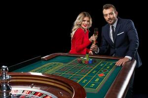 bellissimo e bene vestito coppia giocando roulette nel il casinò foto