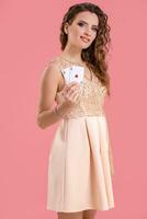 giovane bellissimo donna Tenere il vincente combinazione di poker carte su rosa sfondo. Due assi foto