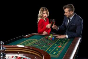 bellissimo e bene vestito coppia giocando roulette nel il casinò foto