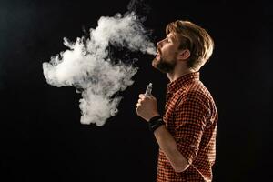un' giovane uomo con un' barba e un' elegante acconciatura nel un' camicia, fumo un' sigaretta, un' vipera, un' camera, un' studio, Fumo, godimento foto