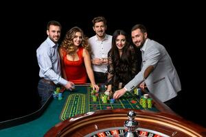 gruppo di giovane persone dietro a roulette tavolo nel un' casinò foto