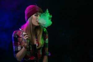 vaping ragazza. giovane fricchettone donna Vape e-cig su nero sfondo. hip-hop stile. studio tiro foto