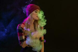 vaping ragazza. giovane fricchettone donna Vape e-cig su nero sfondo. hip-hop stile. studio tiro foto