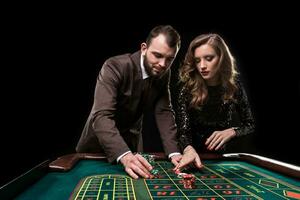 uomo e donna giocando a roulette tavolo nel casinò foto