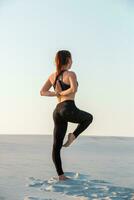 fitness yoga donna allungamento su sabbia. in forma femmina atleta fare yoga posa. foto