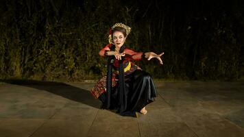 un' giavanese ballerino nel un' rosso costume presentata un' danza quello affascinato il pubblico con il suo abilità foto