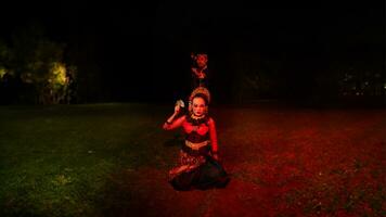un' femmina ballerino nel un' rosso costume sat nel il silenzio di il notte quale rafforzato il tristezza foto
