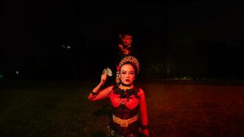 un' gruppo di femmina ballerini con facce pieno di pesante emotivo oneri seduta nel il buio di notte foto