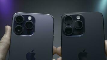 Stati Uniti d'America, nuovo York - settembre 15, 2023. confronto di design di iphone 14 e 15 pro. azione. confronto di ultimo iphone 14 e 15 professionista su isolato sfondo. persona detiene iphone 14 e 15 professionista nel foto