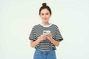 tecnologia e stile di vita. giovane donna in piedi al di sopra di bianca sfondo con smartphone foto