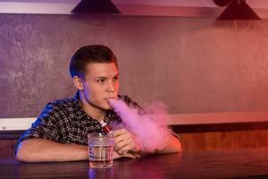 il uomo Fumo un elettronico sigaretta a il Vape negozio. foto