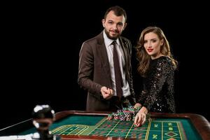 uomo e donna giocando a roulette tavolo nel casinò foto