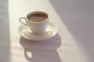 tazza bianca con caffè turco nero su tovaglia bianca foto
