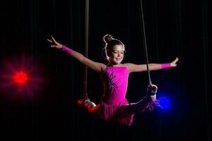 circo artista acrobata prestazione. il ragazza esegue acrobatico elementi nel il aria. circo ginnasta su il palcoscenico foto