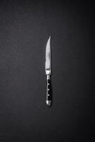 cucina coltello fatto di acciaio su un' buio strutturato sfondo foto