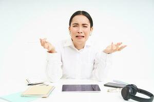 triste giapponese ufficio gestore, donna urlando e urlando, stressato su su opera, si siede nel ufficio con afflitto emozioni, bianca sfondo foto