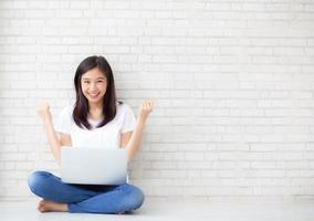 giovane donna asiatica eccitata e felice del successo con il computer portatile.