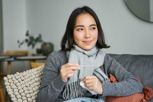 sorridente asiatico donna Tenere termometro e guardare lieto, sensazione meglio dopo freddo, avuto sbarazzarsi di febbre, ha normale temperatura foto