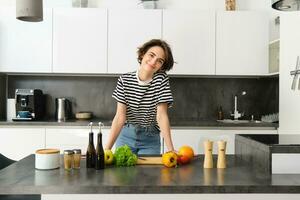 ritratto di giovane donna cucinando insalata. carino ragazza vegano chopping verdure su cucina contatore, preparazione cibo foto