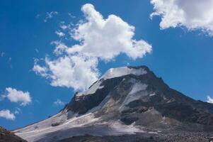 un' montagna con nuvole foto