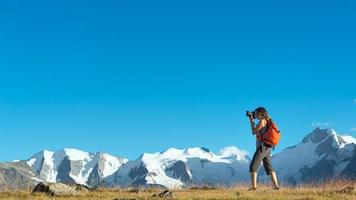 ragazza fotografa le alte montagne delle alpi foto