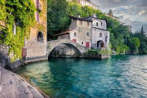 antico paesino con un bel ponte in pietra lungo il lago di como foto