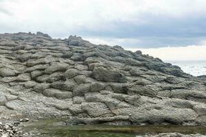 strano costiero paesaggio di Esposto alle intemperie basalto rocce foto