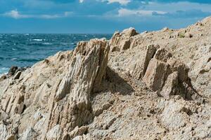 roccioso riva del mare formato di colonnare basalto contro il mare, costiero paesaggio di il kuril isole foto