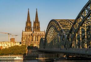 colonia Cattedrale e hohenzollern ponte illuminato di il mattina sole foto