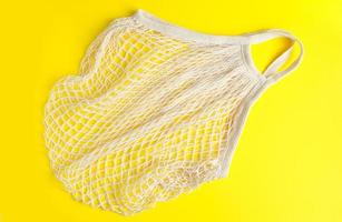 borsa a rete ecologica su sfondo giallo. borsa in cotone organico riciclabile. stile di vita e shopping sostenibili. foto