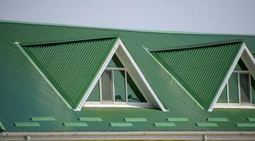 il Casa con plastica finestre e un' verde tetto di ondulato foglio. verde tetto di ondulato metallo profilo e plastica finestre. foto