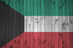 Kuwait bandiera raffigurato nel luminosa dipingere colori su vecchio di legno parete. strutturato bandiera su ruvido sfondo foto