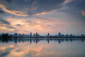 al tramonto, il lago riflette la vista notturna della città foto