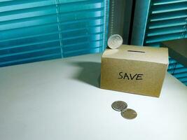 un' scatola di risparmi e monete impilati su un' tavolo, per sfondo scopo foto
