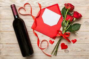 San Valentino giorno composizione con rosso vino, rosa fiore e regalo scatola su tavolo. superiore Visualizza, piatto posizione. vacanza concetto foto