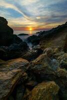 tramonto al di sopra di il oceano con rocce a chanthaburi, Tailandia. foto