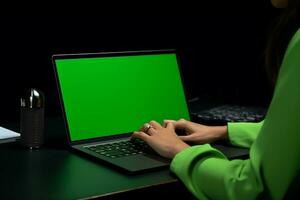 ai generato un' donne Lavorando su il il computer portatile con verde schermo foto