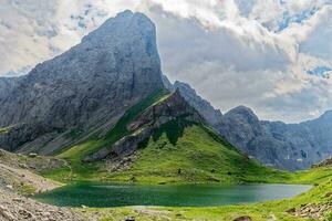 Visualizza di volaia lago, wolayersee, nel il confine di Italia e Austria con cogliani montagna nel il sfondo. nuvoloso giorno con alcuni sole apertura. vivace colori. bellissimo destinazioni per escursionisti. foto