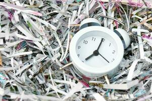 Vintage ▾ bianca allarme orologio su un' sfondo di triturati carta. foto