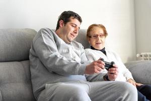 uomo adulto e donna anziana con gamepad a casa foto