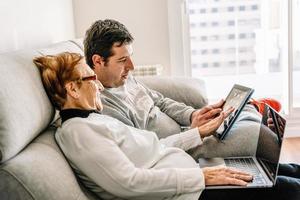 uomo allegro e donna anziana che usano il laptop insieme foto