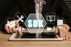 sdk - Software sviluppo kit programmazione linguaggio tecnologia concetto, persona utilizzando digitale tavoletta con sdk icona su virtuale schermo. foto