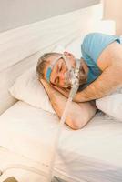 l'uomo addormentato con problemi respiratori cronici considera l'uso della macchina cpap a letto. assistenza sanitaria, terapia dell'apnea ostruttiva del sonno, cpap, concetto di russamento foto