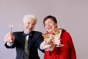 due belle donne anziane mature alla moda che celebrano il nuovo anno. divertimento, festa, stile, concetto di celebrazione foto